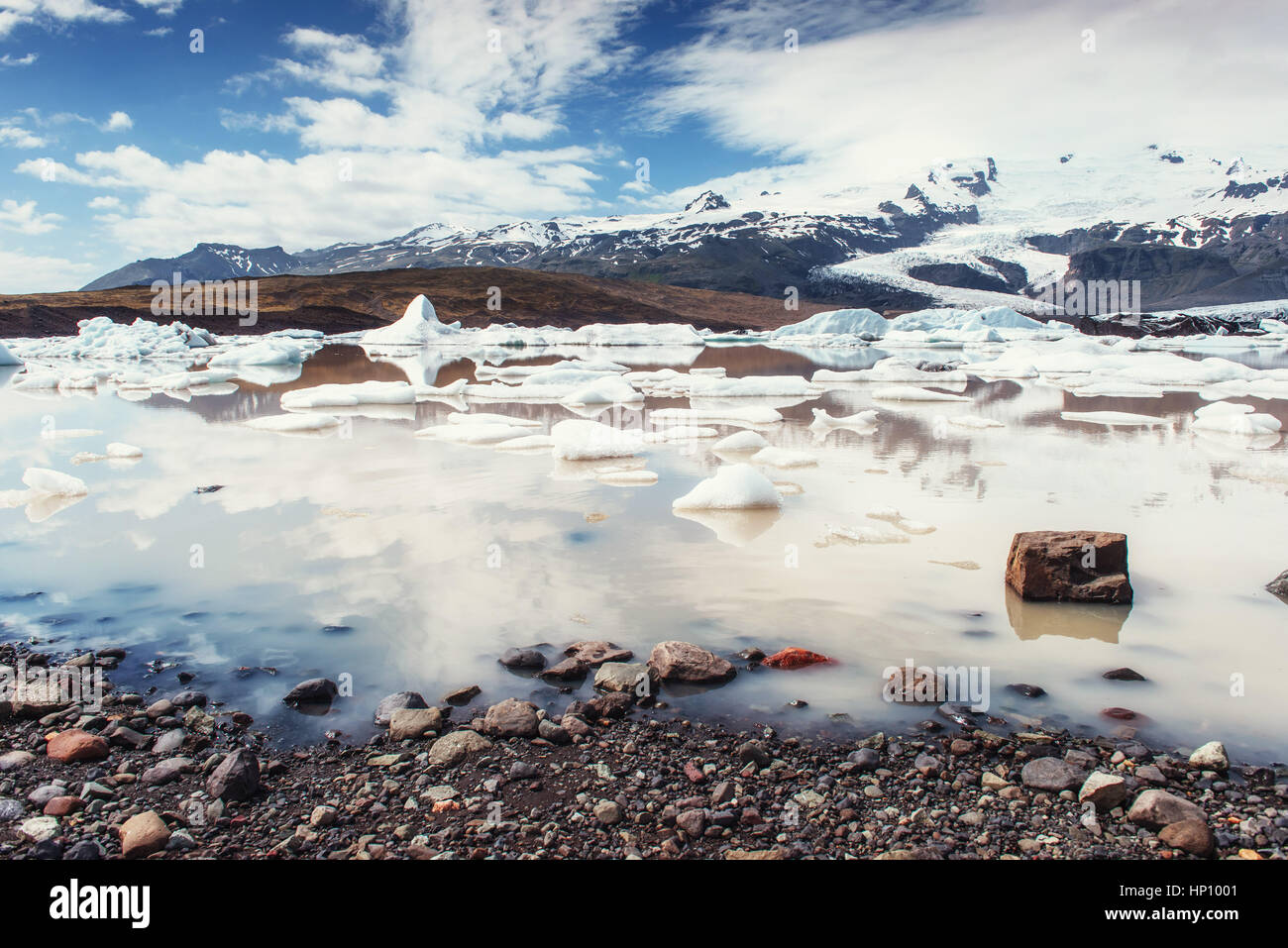 Iceberg laguna glaciale Fjallsarlon. Cumulus nuvole bianche riflettono Foto Stock