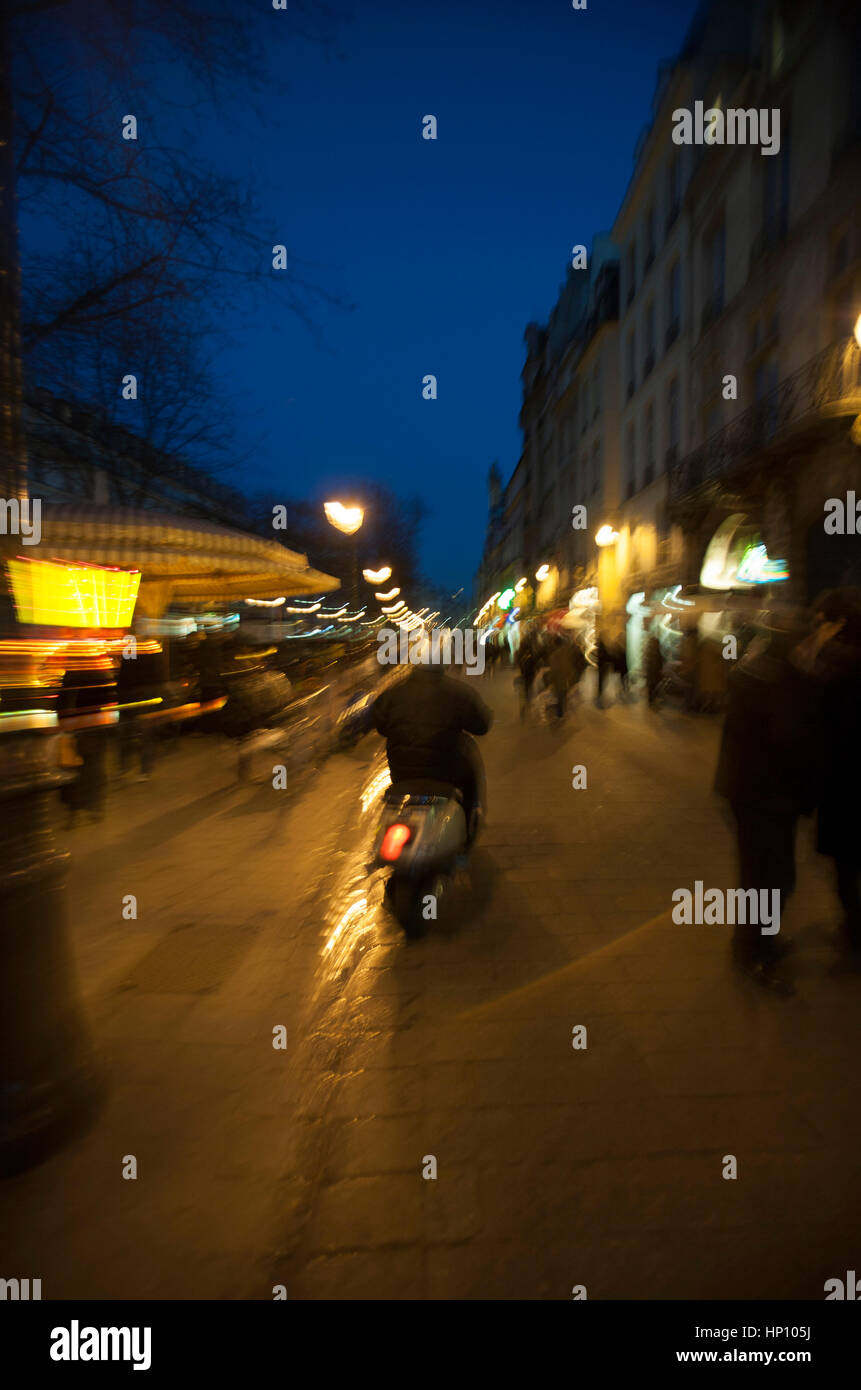 Francia, Parigi, persona che guida motociclo su strada al crepuscolo Foto Stock