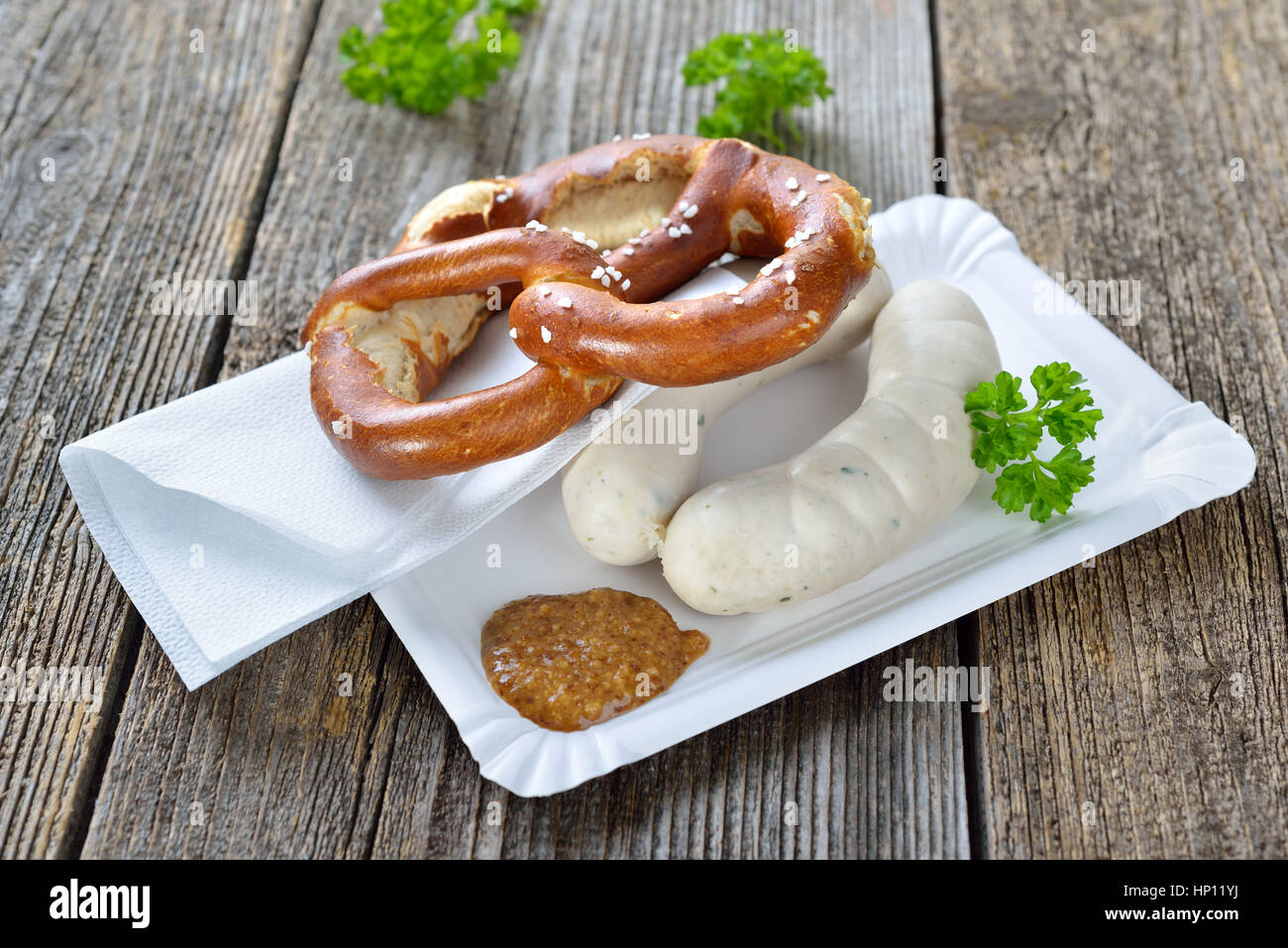 Bavarese di cibo di strada: Due Monaco di Baviera le salsicce bianche con una fresca pretzel e senape dolce su un piatto di carta Foto Stock