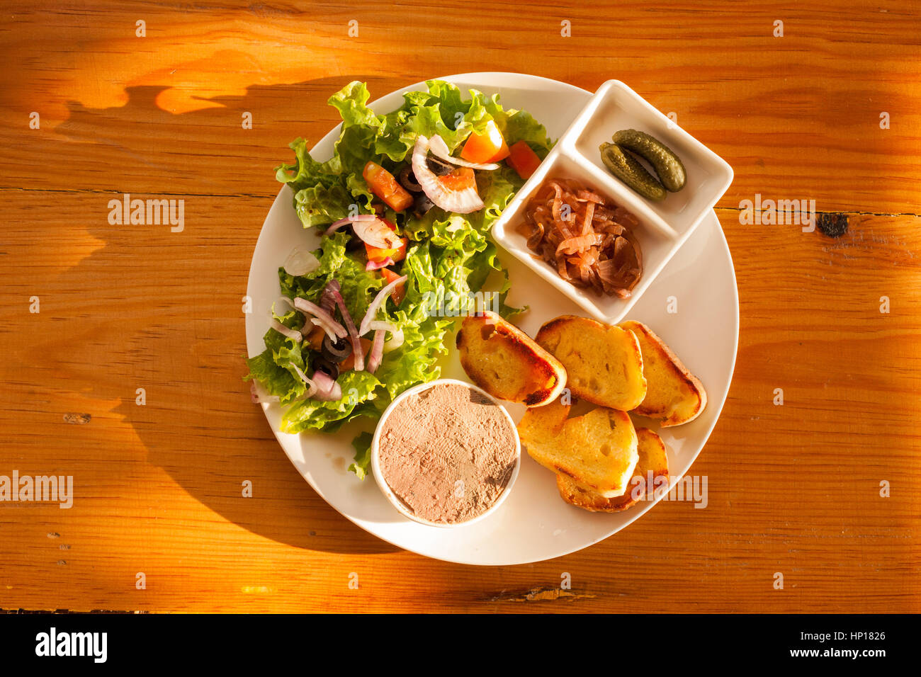 Paté di fegato con insalata e aglio pane su una tavola di legno Foto Stock