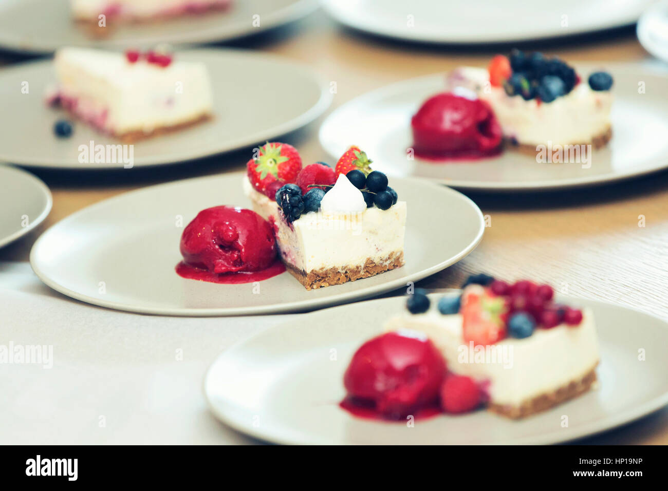 Cheesecake con frutti di bosco e sorbetto su piastre Foto Stock