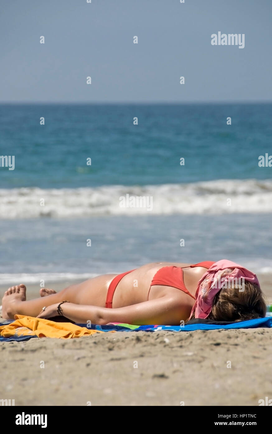 Frau im Bikini sonnt sich am Sandstrand - donna in bikini suns in spiaggia Foto Stock