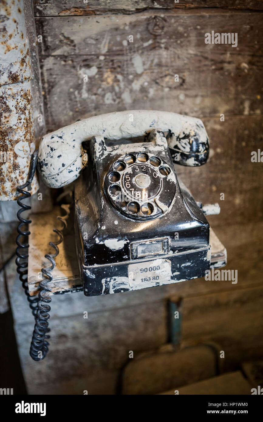 Close up Dirty old black bakelite telefono ricoperta di argilla in un laboratorio di ceramica Foto Stock