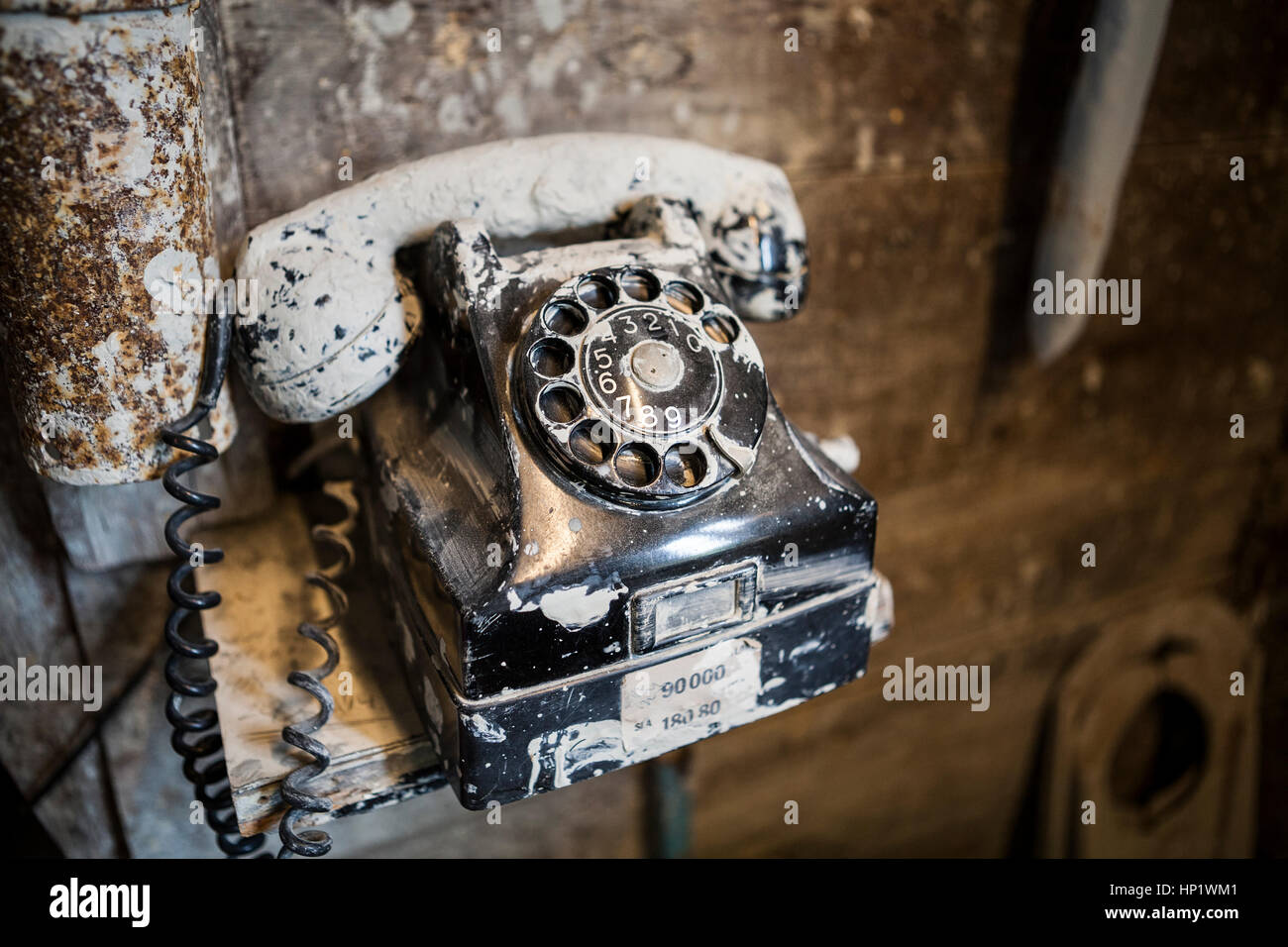 Close up Dirty old black bakelite telefono ricoperta di argilla in un laboratorio di ceramica Foto Stock
