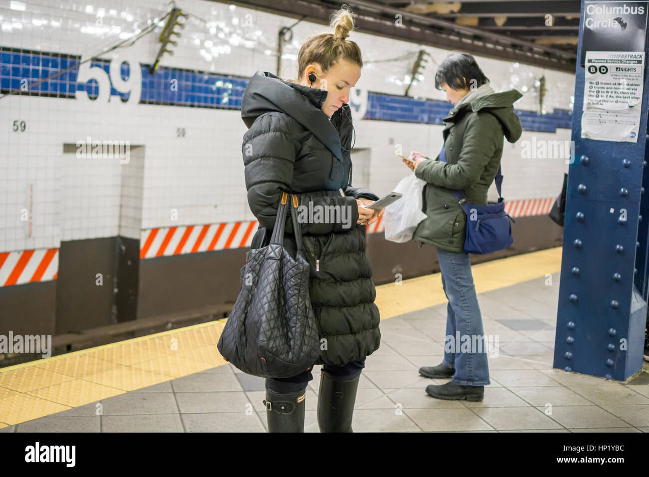 Rider preoccupato con il suo smartphone su una piattaforma della metropolitana a New York Sabato, 11 febbraio 2017. (© Richard B. Levine) Foto Stock
