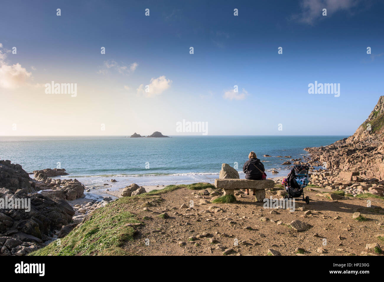 Madre bambino seduto al banco in granito porth nanven Cornwall Inghilterra Regno Unito Foto Stock