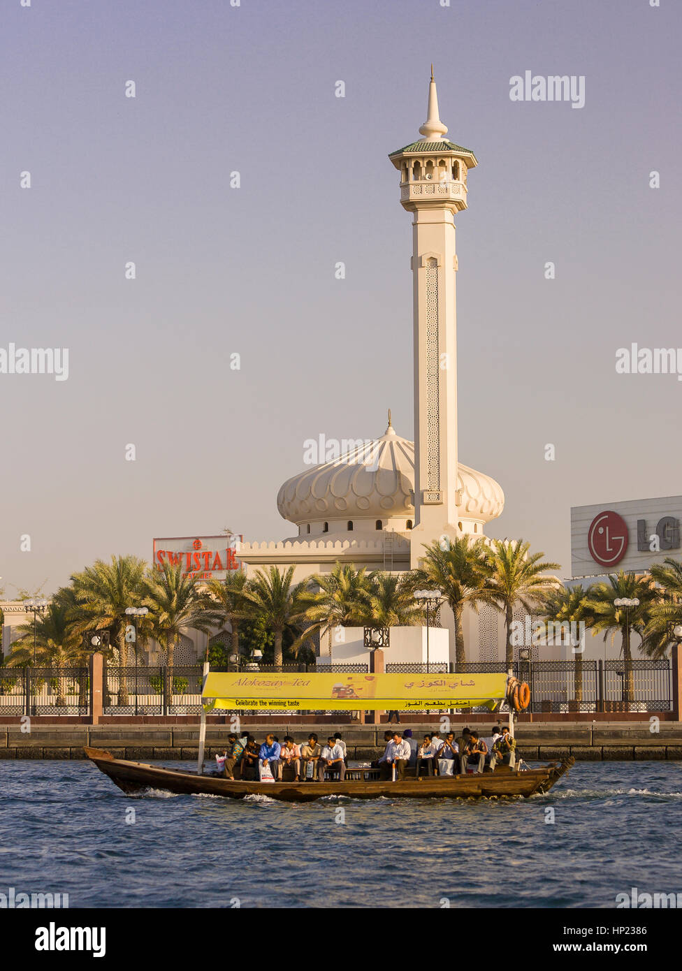 DUBAI, Emirati Arabi Uniti - acqua Abra taxi traghetti passeggeri su Dubai Creek con moschea a posteriori. Foto Stock