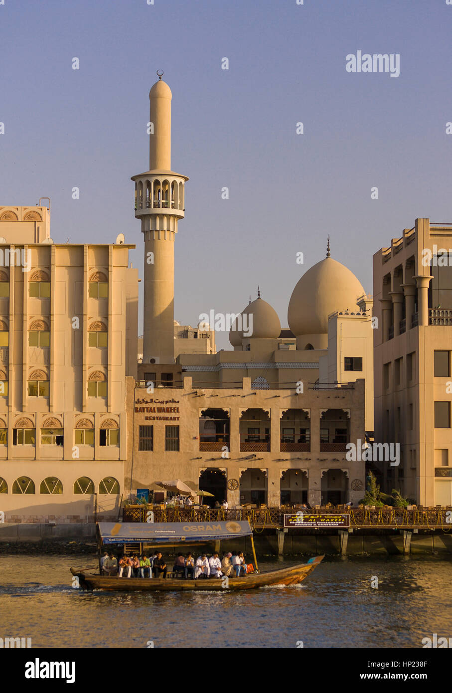 DUBAI, Emirati Arabi Uniti - acqua Abra taxi traghetti passeggeri su Dubai Creek con moschea a posteriori. Foto Stock