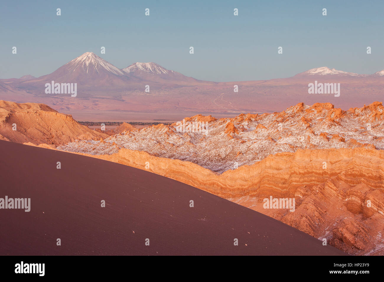 Valle de la Luna (Valle della Luna), sullo sfondo dei vulcani di sinistra Licancabur e Juriques con neve in cima, e sale depositato sul più vicino mo Foto Stock