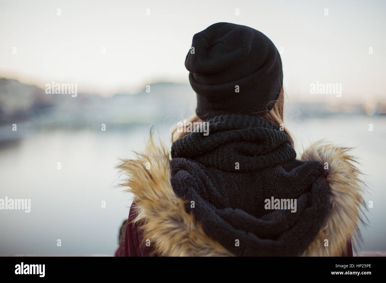 Vista posteriore di un triste hipster ragazza contro sfocato Sfondo Inverno Foto Stock