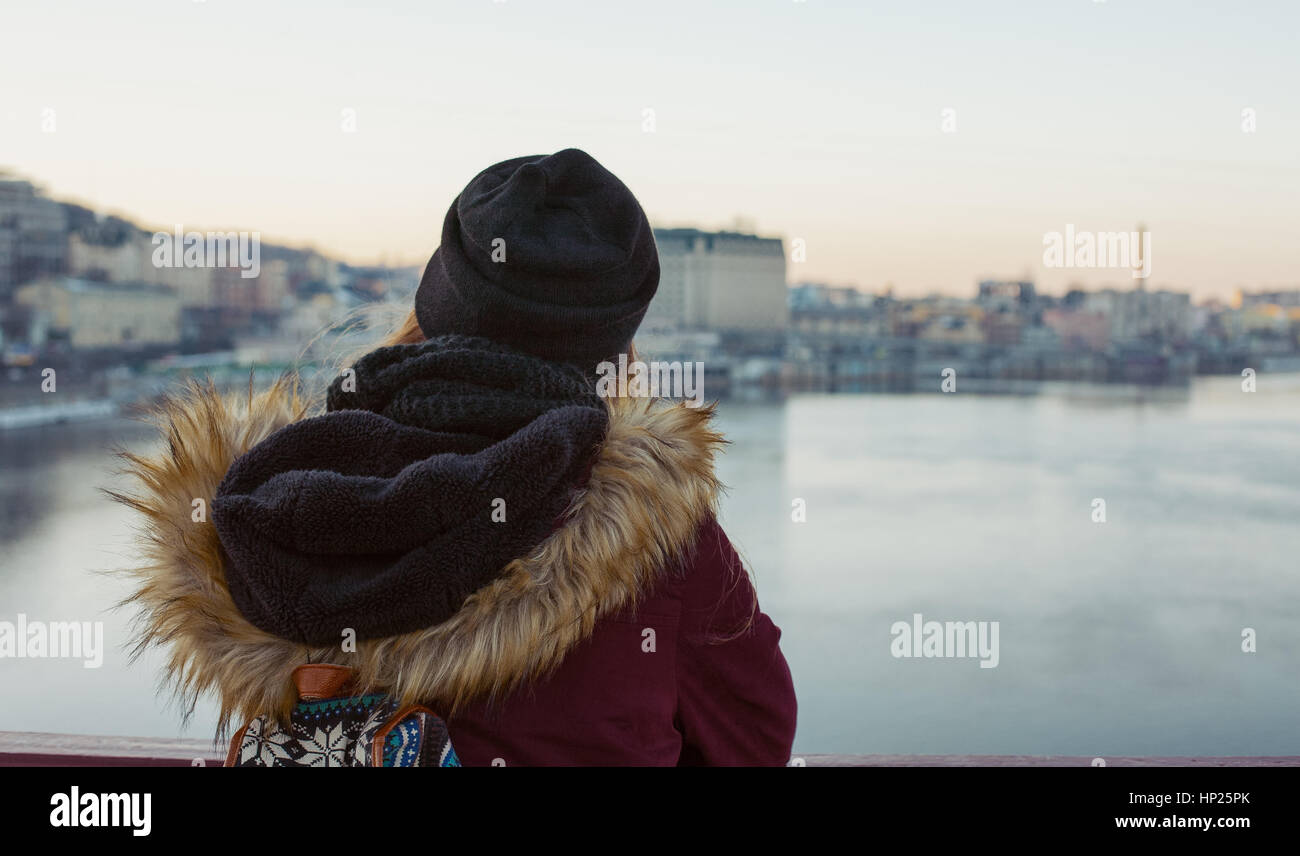 Ragazza traveler in piedi sul ponte di godere il panorama della città attraverso il fiume Foto Stock