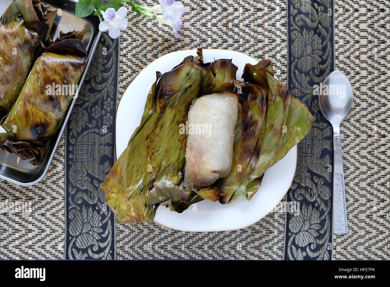 Khao Ping nio è arrosto dolci di riso appiccicoso con il latte di cocco e il taro all'interno di riempimento, su foglie di banano. Treditional Thai dessert di stile. Foto Stock