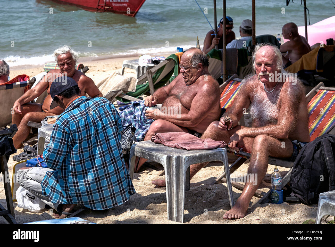 Maschio maturo turistico con ampio corpo capelli coprendo e peloso torace, a prendere il sole sulla spiaggia di Pattaya Thailandia Foto Stock