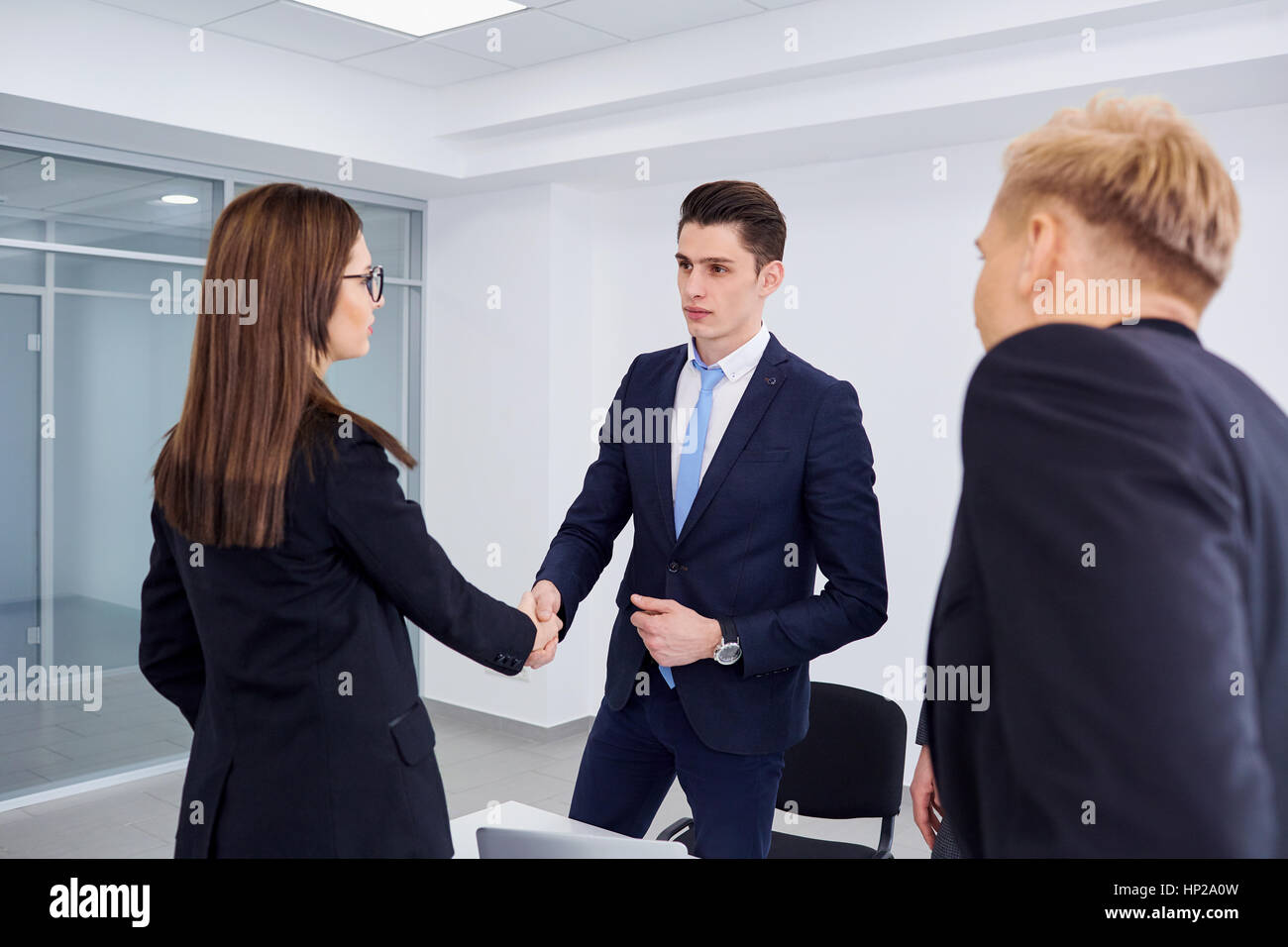 Stretta di mano la gente di affari. Un gruppo di uomini di affari al banco in mo Foto Stock