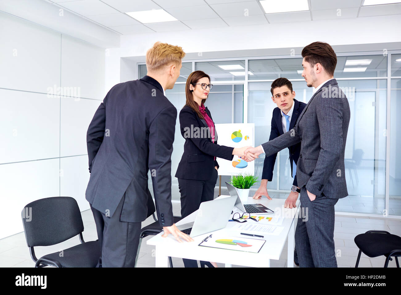 Stretta di mano la gente di affari. Un gruppo di uomini di affari al banco in mo Foto Stock