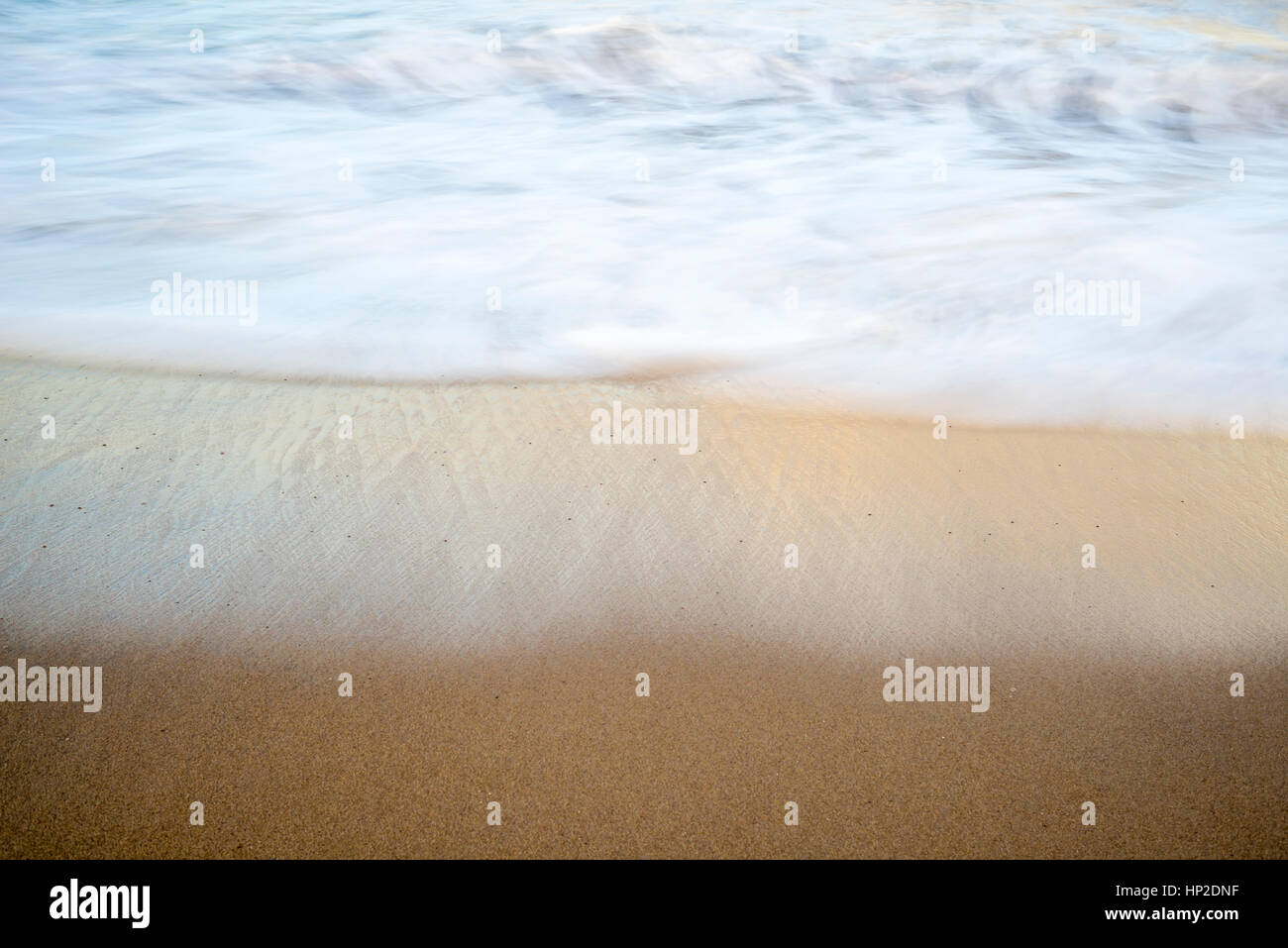 In prossimità della spiaggia di sabbia e onde. lunga esposizione dell'immagine. Foto Stock