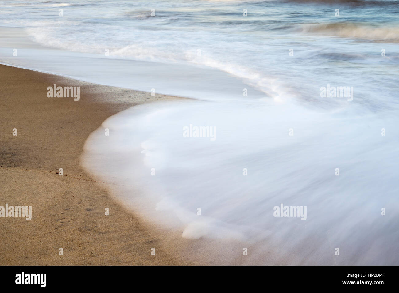 In prossimità della spiaggia di sabbia e onde. lunga esposizione dell'immagine. Foto Stock