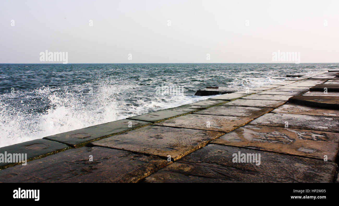 Vecchio cemento, pietra pier in mare. Bellissimo mare scuro con colori ricchi Foto Stock