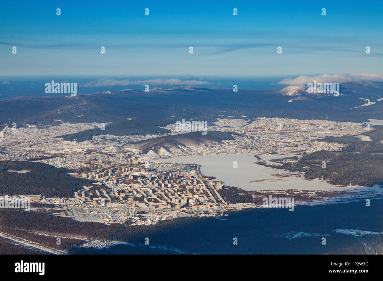 Vista da sopra del centro industriale degli Urali città di Zlatoust in inverno, circondato da montagne invernali. Foto Stock