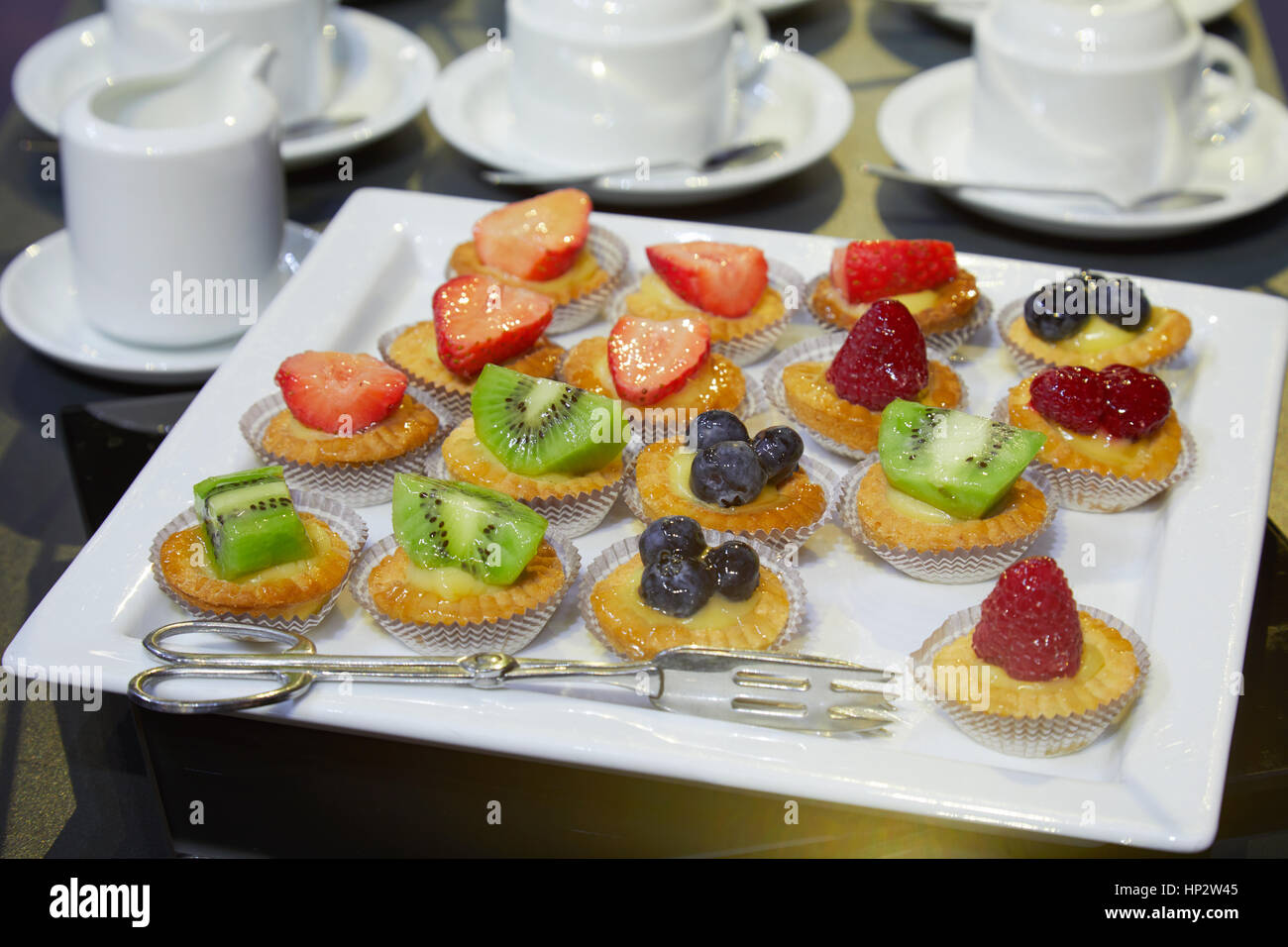 La pasticceria con frutta e tazze da caffè pronto per colazione in hotel Foto Stock