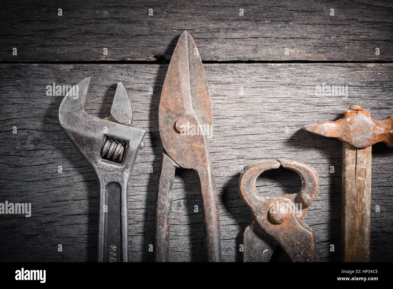 Vecchi strumenti di fabbro su un grigio e incrinato sfondo di legno. Spazio per il testo. Vista da sopra. Foto Stock