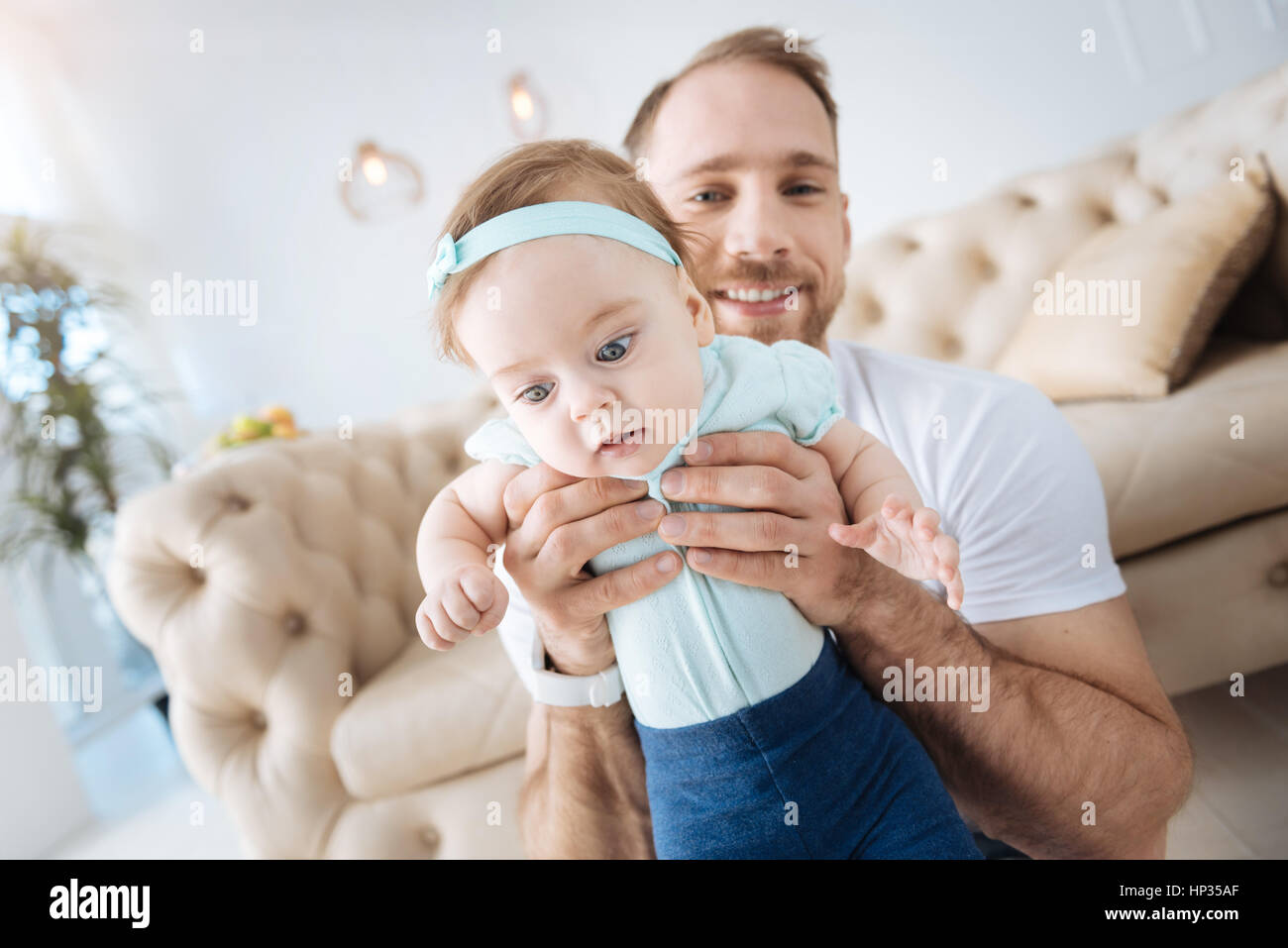 Coinvolti bambino nelle braccia del padre a casa Foto Stock
