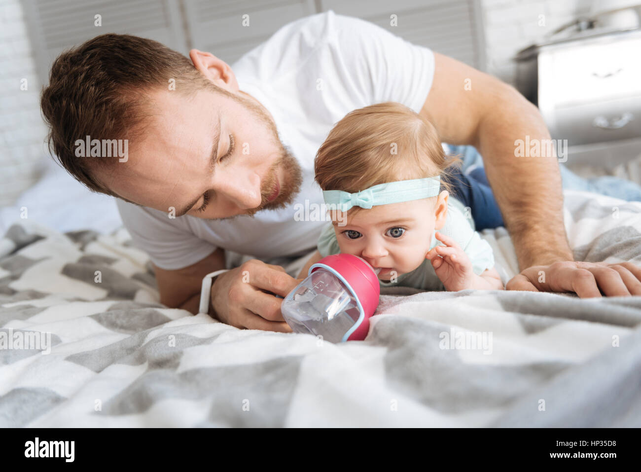 Padre attenta alimentazione di sua figlia a casa Foto Stock