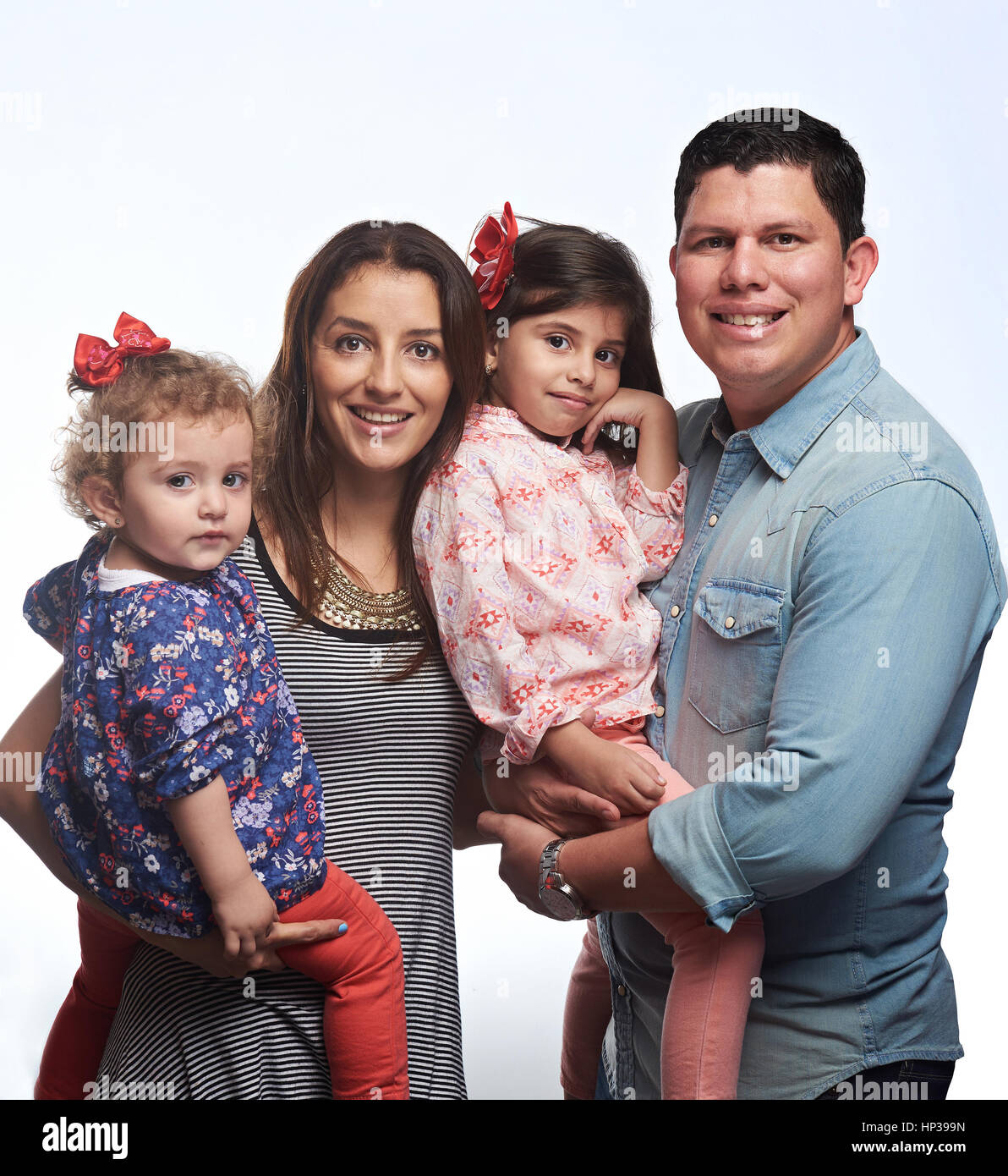 Carino giovane famiglia di quattro con piccoli ragazze ragazzi isolati su sfondo bianco Foto Stock