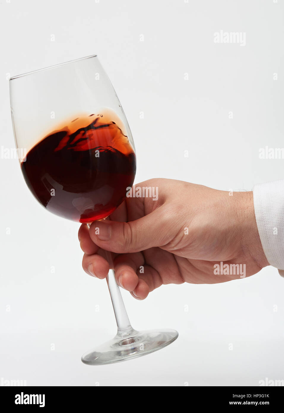 Spostando il vino rosso in vetro gambo isolato su sfondo bianco. Test di vino rosso. Close up di bere vino rosso Foto Stock
