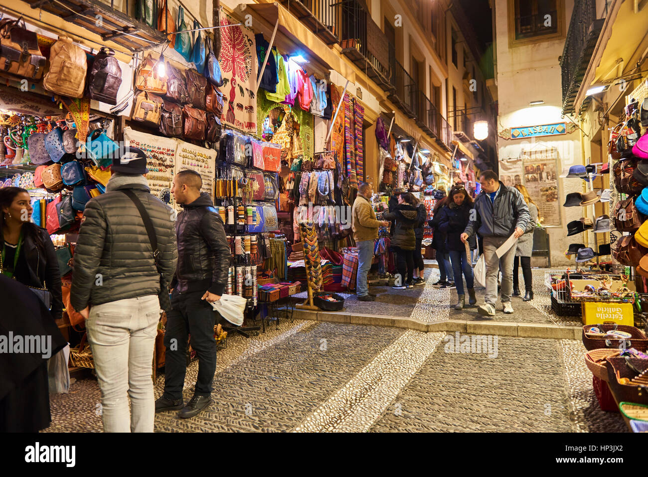 Turisti e negozi di souvenir vendono artigianato marocchino di notte, Granada, Andalusia, Spagna, Europa Foto Stock