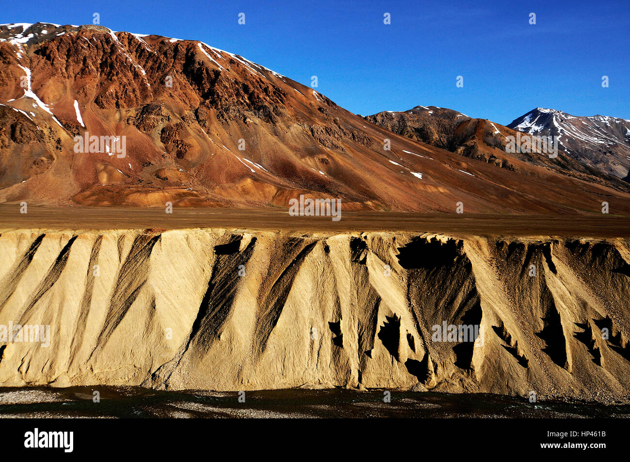 Alta altitudine montagne brulle dell Himalaya, Ladakh, India con crateri creati dal fiume e venti forti, un po' di neve Foto Stock