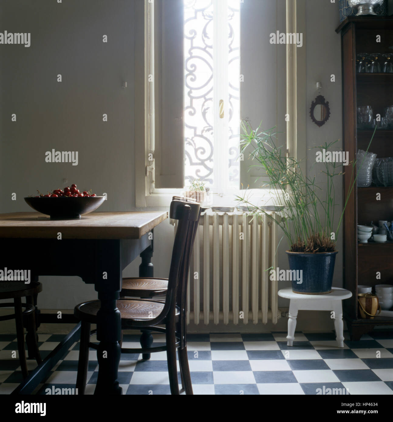 Interno di una contemporanea bellissima cucina in un appartamento italiano: tavolo e sedie e una ciotola con ciliegie Foto Stock