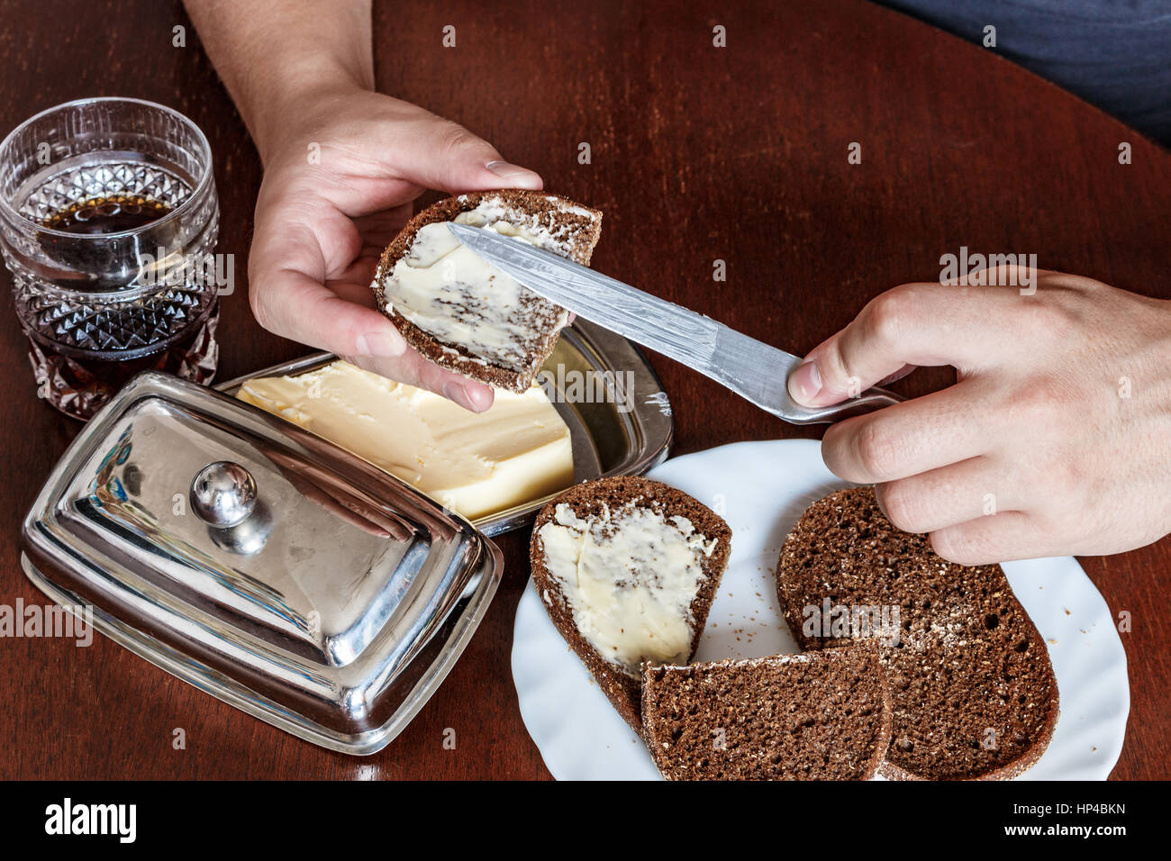 Uomo di pane imburrato coltello. Egli è mancino. mano sinistra, mano maschio. zuppa, pane burro coltello Foto Stock