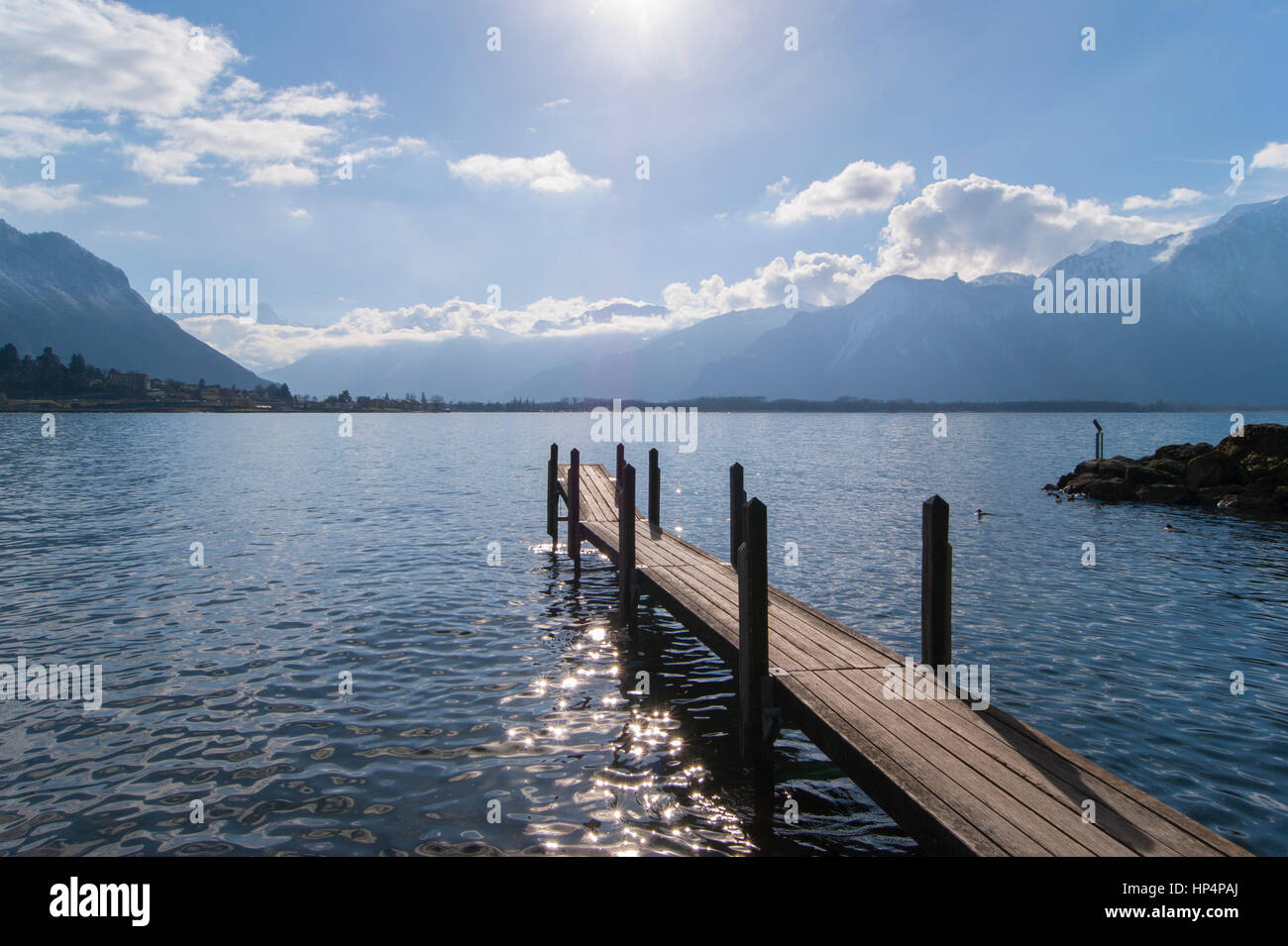 Molo di legno sul Lago di Ginevra vicino al Castello di Chillon (Château de Chillon), Veytaux, Canton Vaud, Svizzera, in una giornata di sole Foto Stock