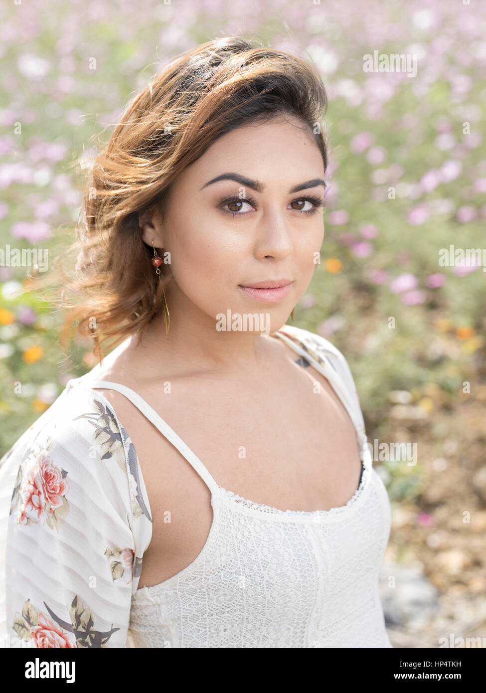 Giovane donna sorrisi nel campo dei fiori cosmos Foto Stock