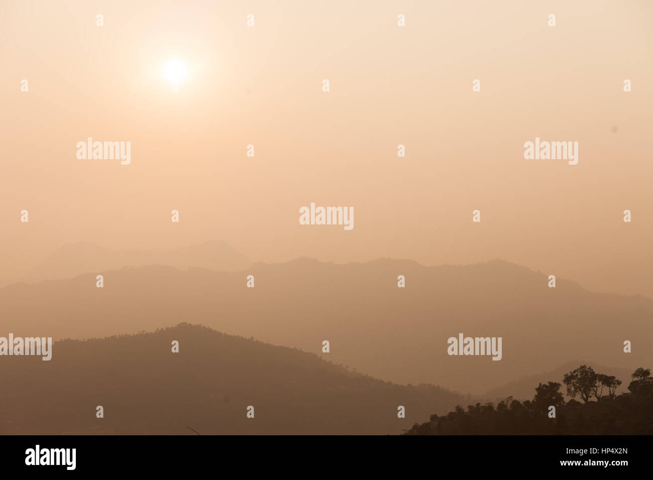 Sun e marrone con haze stagliano colline, Nepal Foto Stock