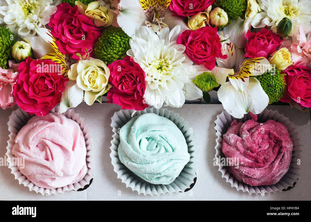 Rose marshmallows e bellissimi fiori su uno sfondo bianco wo Foto Stock