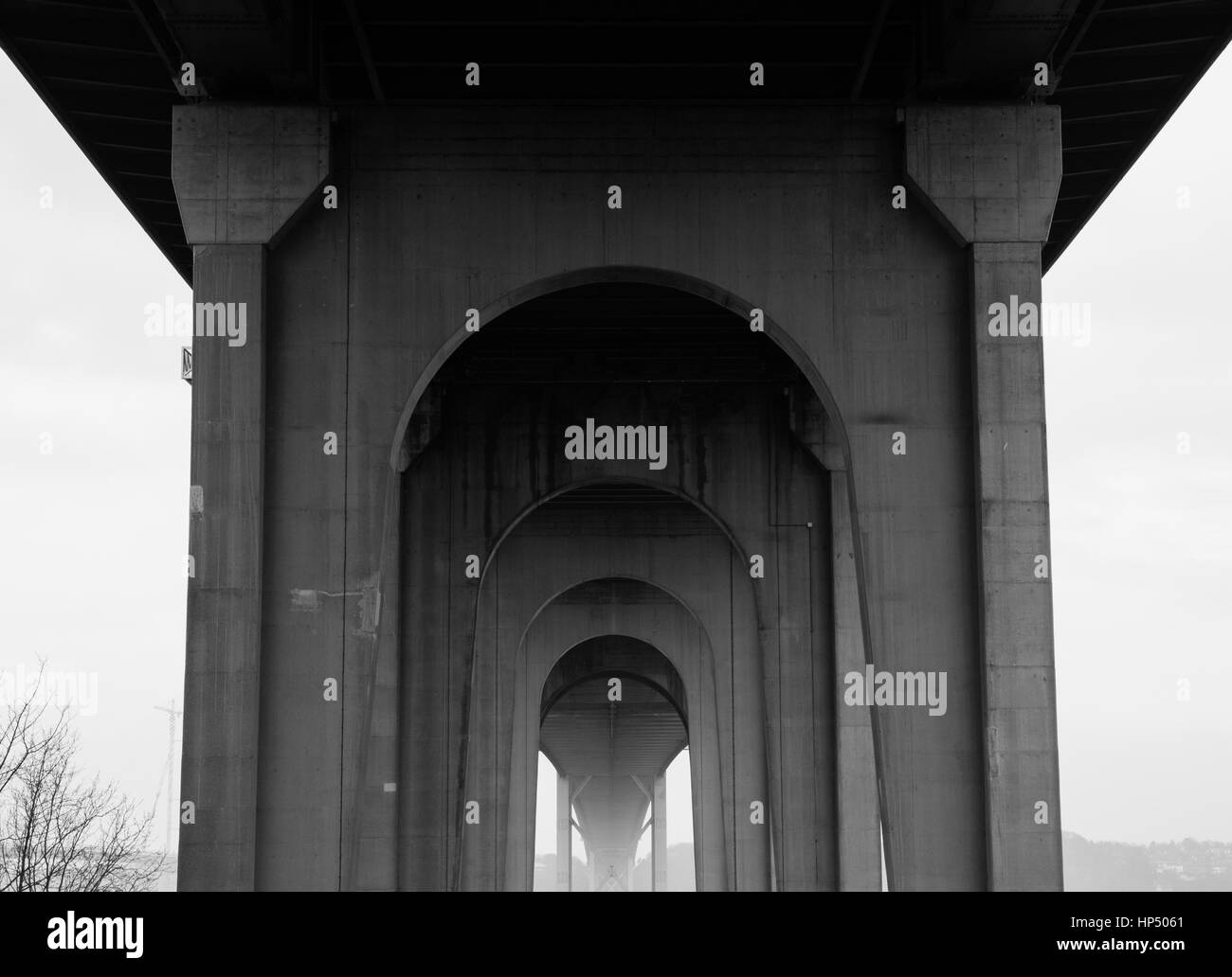Foto in bianco e nero di archi ripetuti in lontananza sotto l'estremità sud del Forth Road Bridge, Scozia, Regno Unito Foto Stock