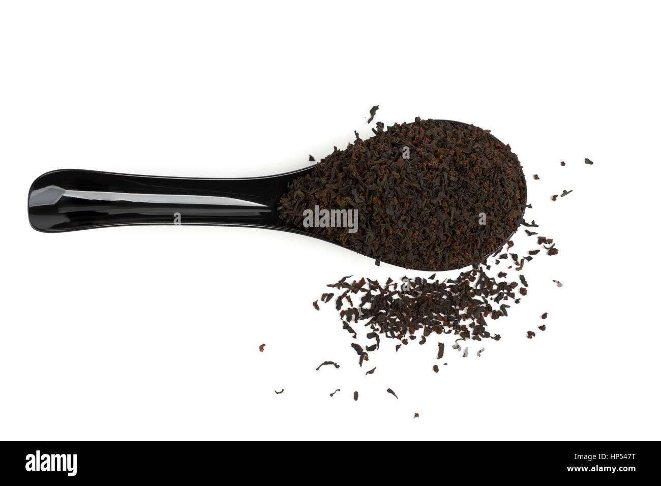 In plastica nera cucchiaio colmo di tè nero isolato su bianco. Vista superiore. Foto Stock