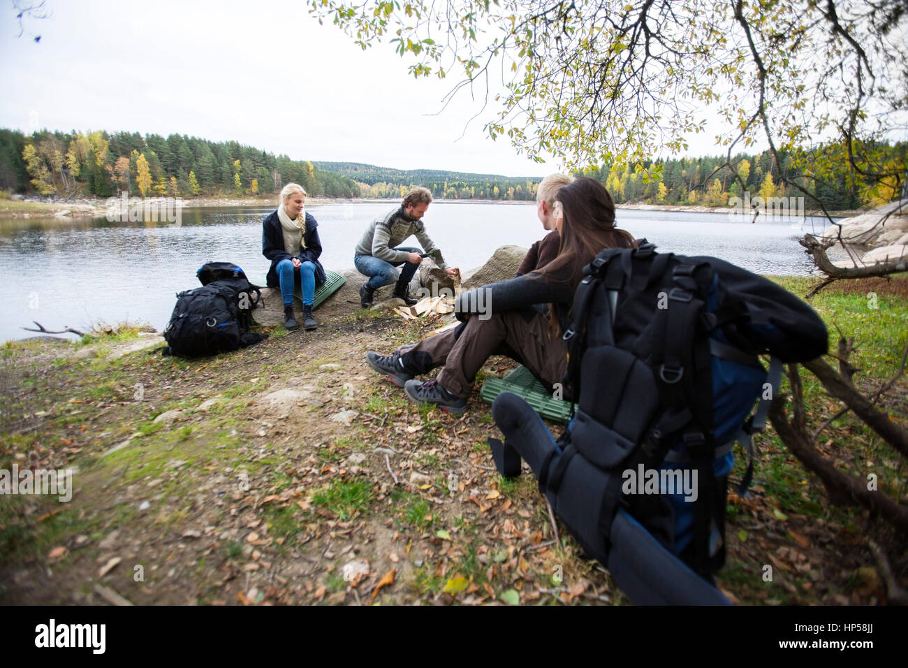 Amici preparando per camping sul lago Foto Stock