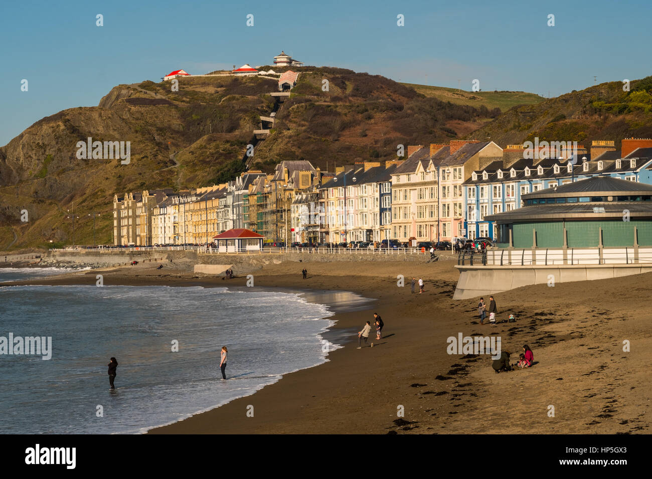 Aberystwyth, Wales, Regno Unito. Il 18 febbraio 2017. Per coloro che godono di un unseasonably calda e soleggiata giornata invernale e sulla spiaggia. Oggi le temperature raggiunte come alto come 13 gradi C, con solo la luce a sud-ovest si snoda. Credito: Alan Hale/Alamy Live News Foto Stock