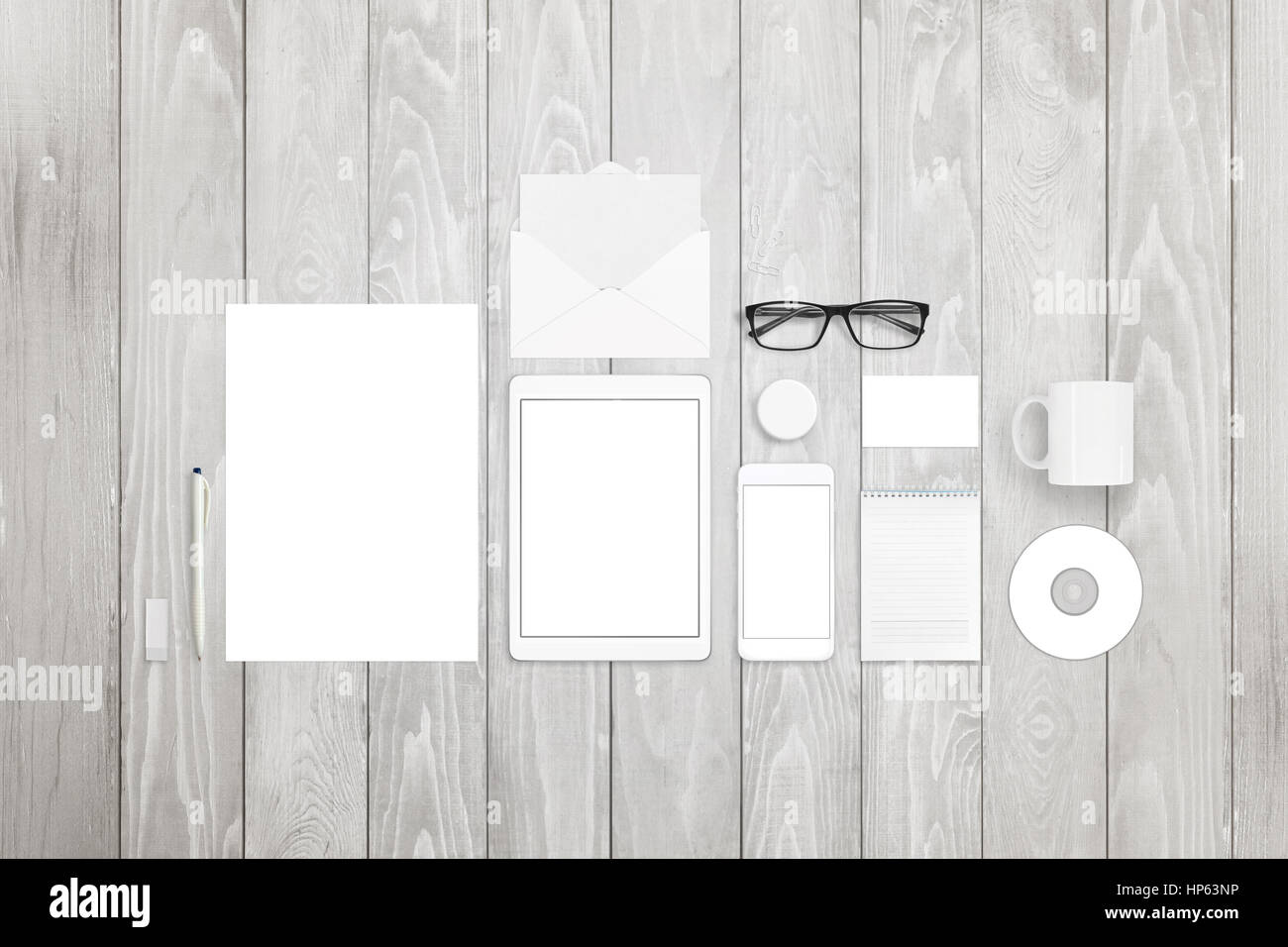 Fermo mock-up comprende carta, taccuino, tablet, smart phone, business card, penna, bicchieri, compact disk, mug e badge pin su legno bianco backgro Foto Stock