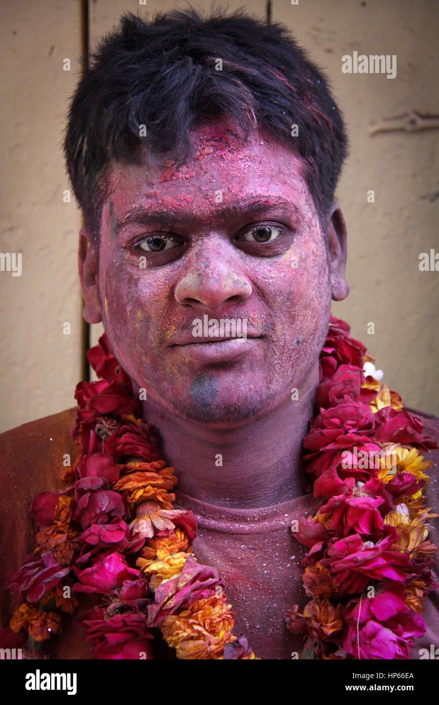 Ritratto di uomo con fiori collana durante Holi celebrazioni in Vrindavan, India Foto Stock