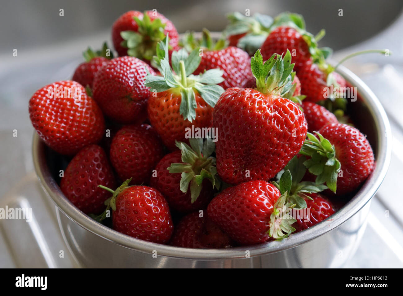 Una tazza di fragole sul banco di cucina Foto Stock