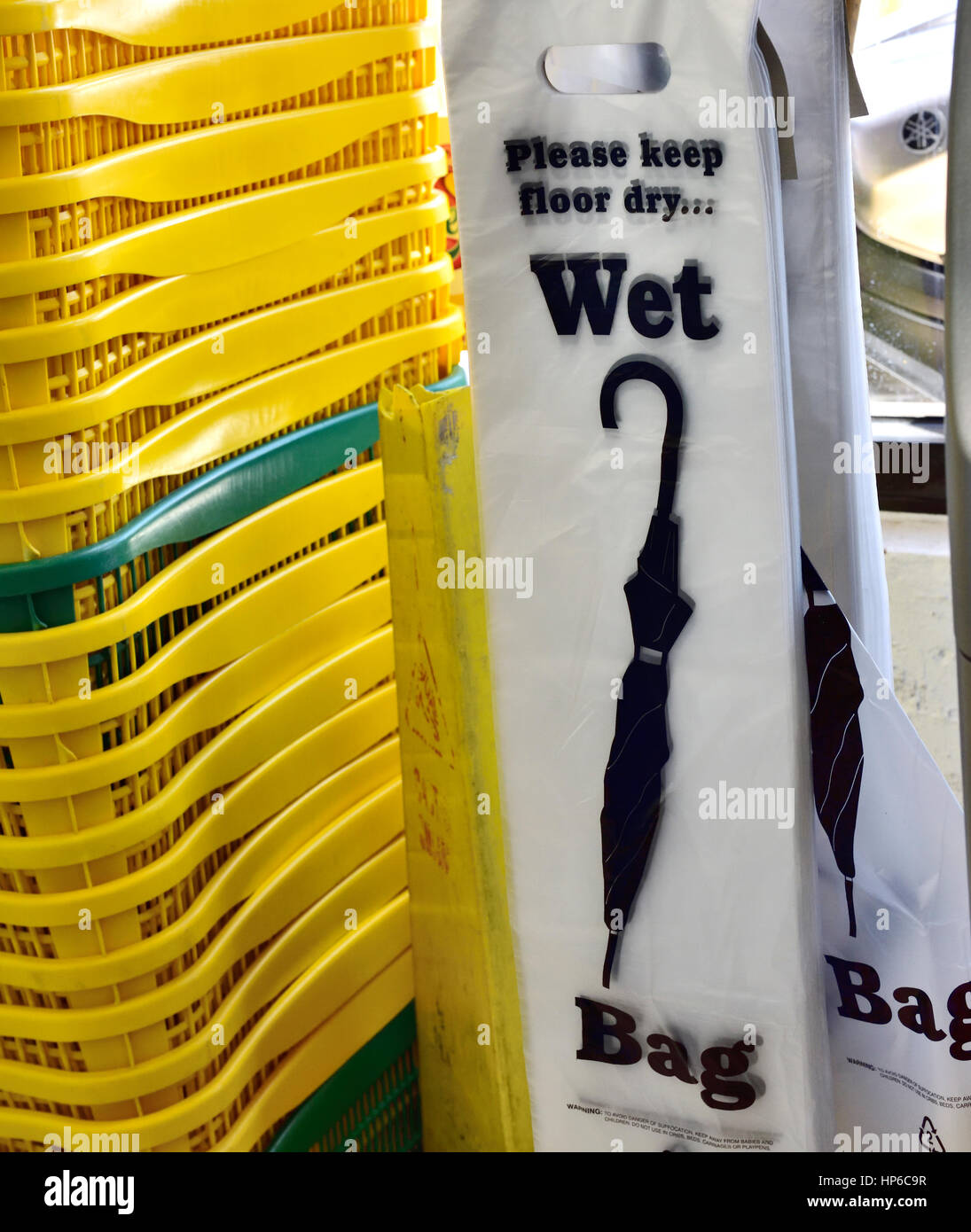 Buttare via i sacchetti di plastica per wet ombrelloni disponibili in negozio per mantenere asciutto il pavimento Foto Stock