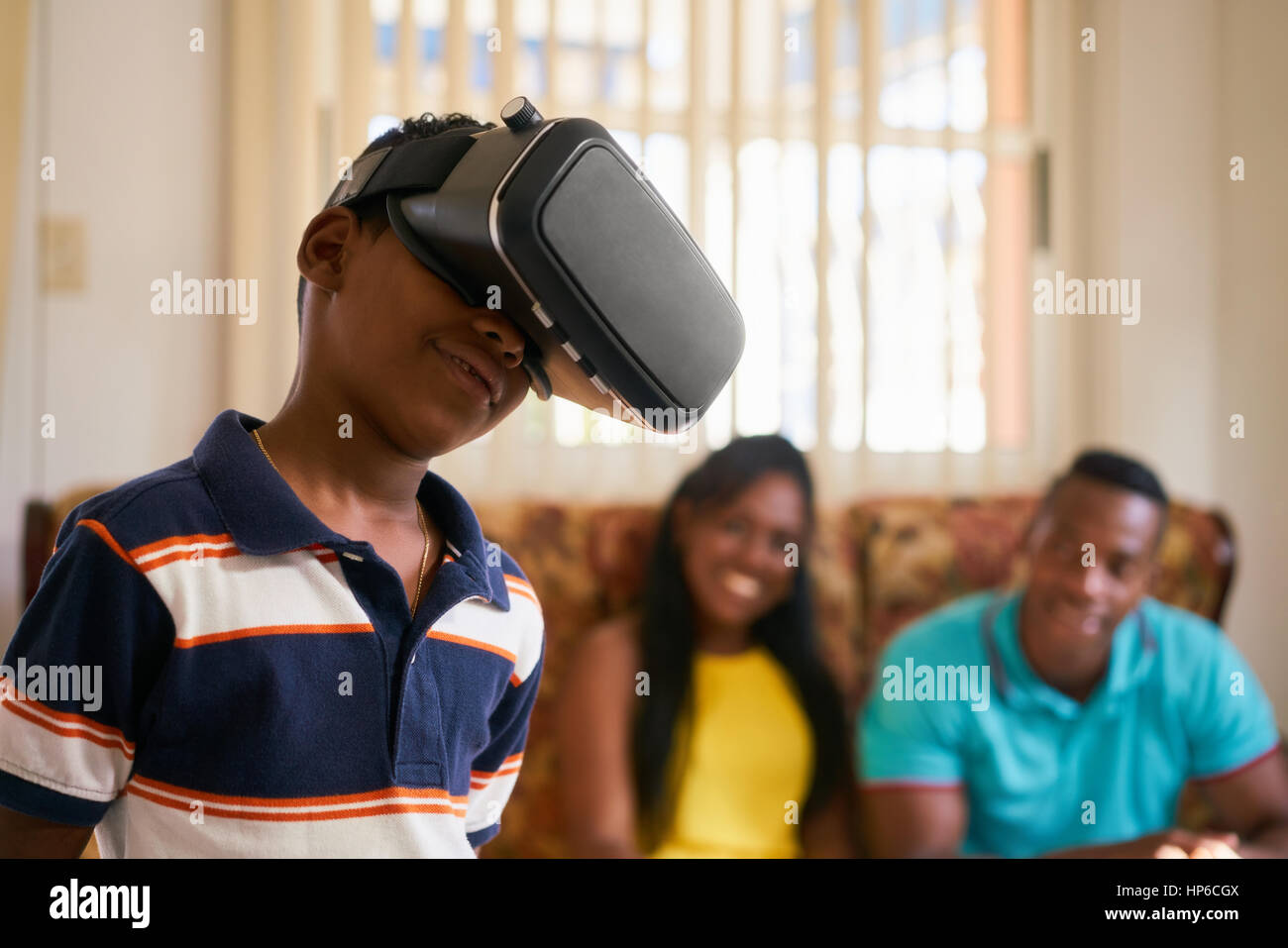 Felice famiglia nero a casa. African American padre, madre e bambino. Uomo Donna e bambino a giocare con la realtà virtuale occhiali, VR, cuffie moderne tec Foto Stock