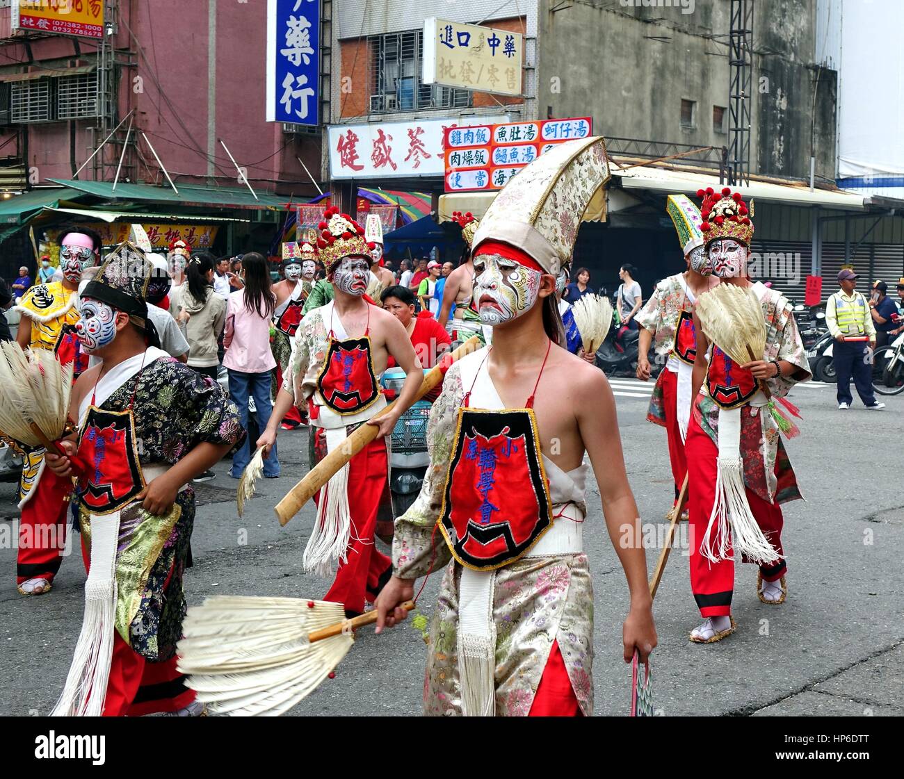 KAOHSIUNG, Taiwan -- Luglio 9, 2016: giovani uomini in costumi tradizionali e dipinte di maschere facciali prendere parte in un tempio locale cerimonia. Foto Stock