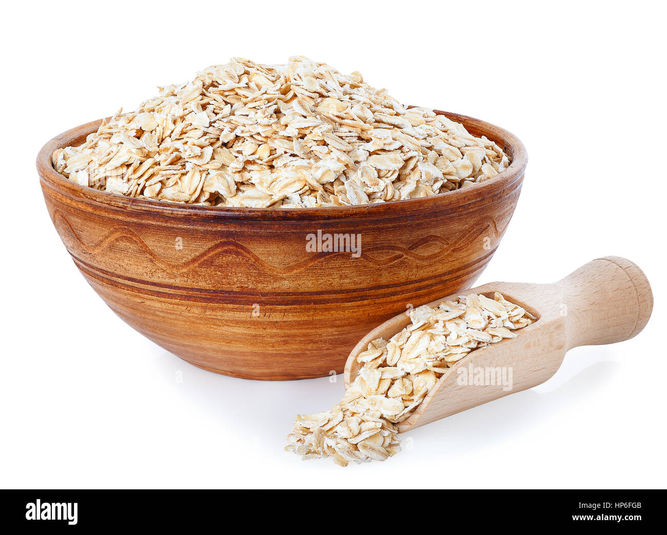 Fiocchi di avena nel recipiente di argilla e scoop di legno isolato su uno sfondo bianco. Cibo sano. Semole e semolini di sano. Vaso in ceramica con cereali. I fiocchi d'avena Foto Stock