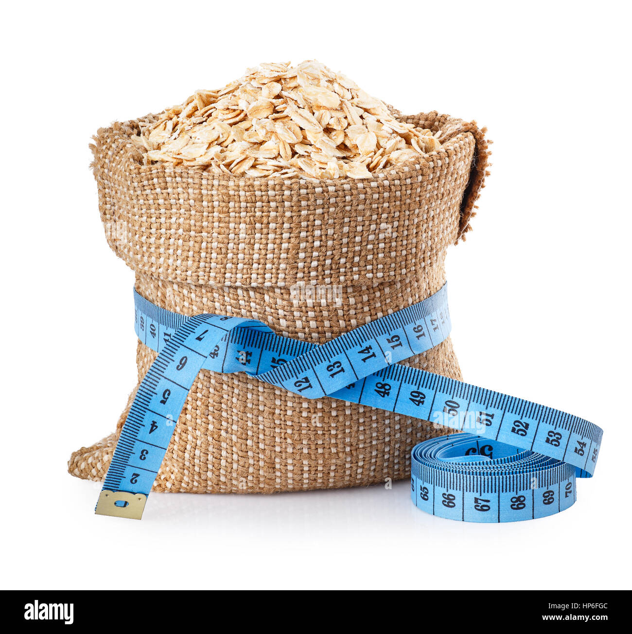Fiocchi di avena nel sacchetto con nastro di misurazione isolata su sfondo bianco. Concetto sana dieta alimentare. Perdere peso. Cibo per il fitness Foto Stock