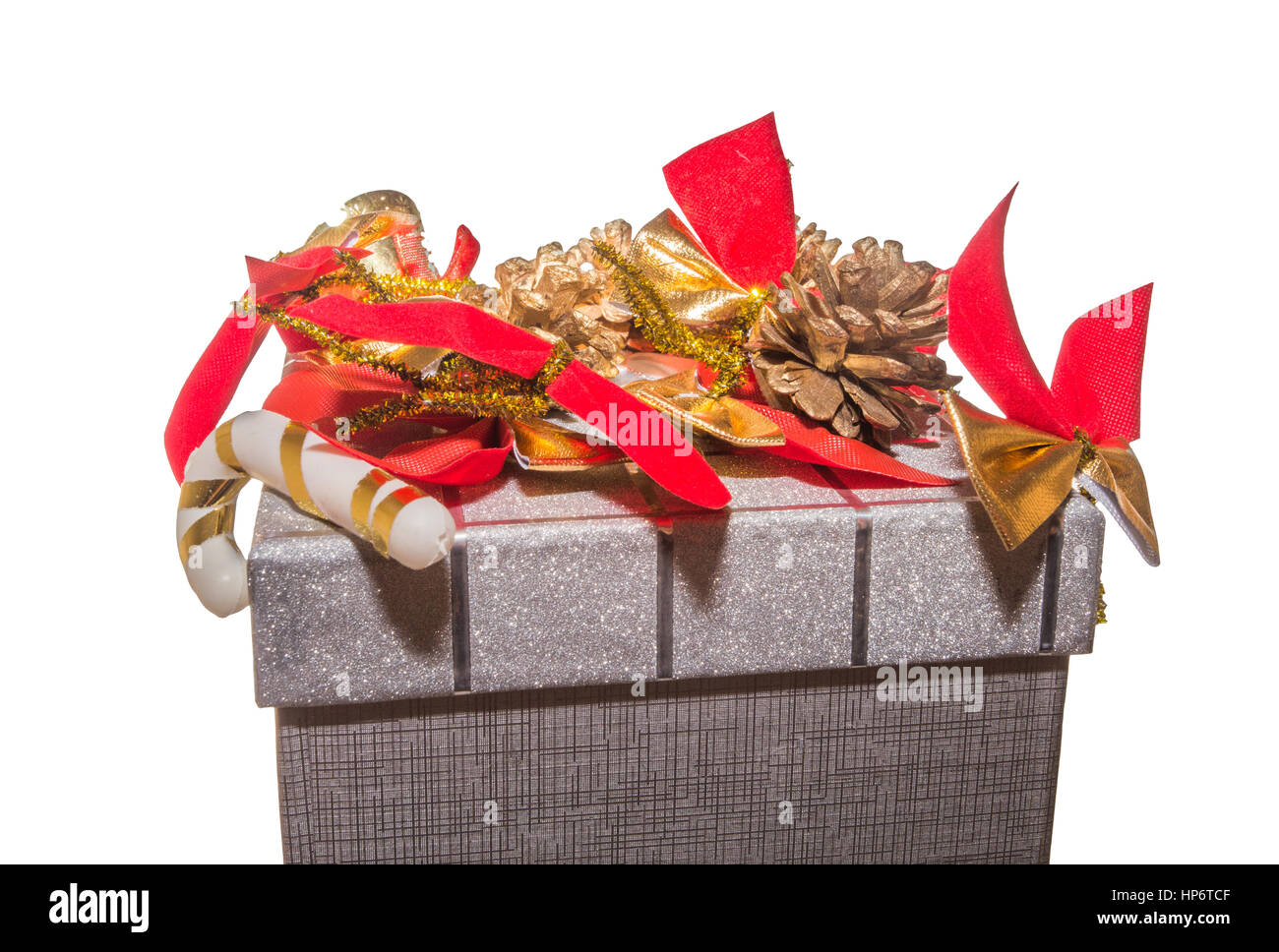 Natale decorato confezione regalo. Parte superiore della scatola regalo decorata con archi rossi e pigne. Decorate confezione regalo isolato su sfondo bianco. Foto Stock